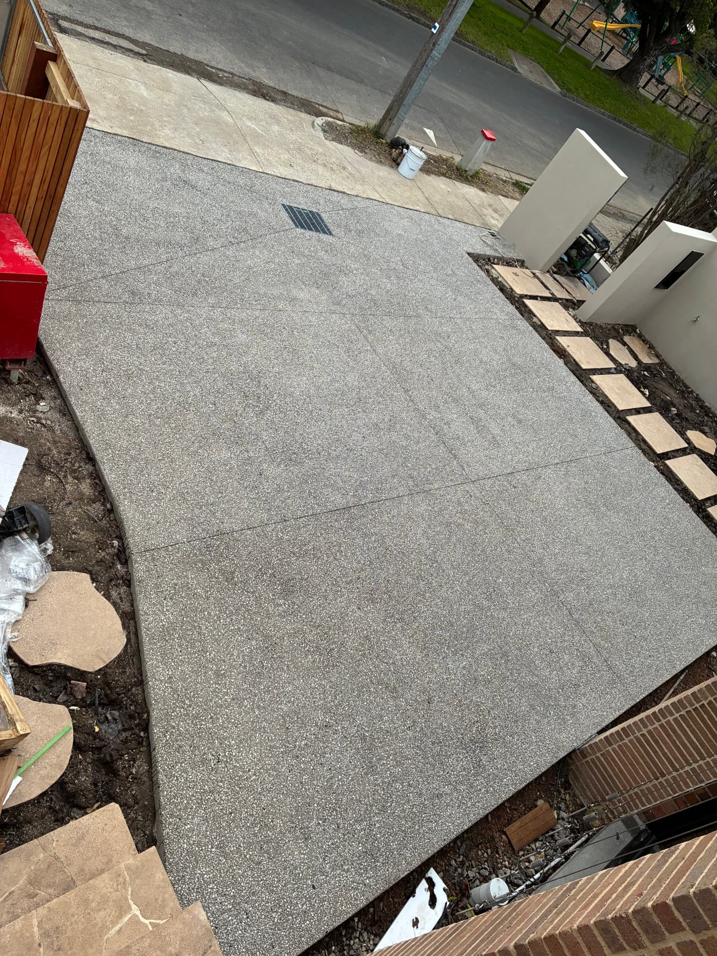 Exposed aggregate driveway — Wide driveway with crossover access, grated drainage point and saw-cut control joints