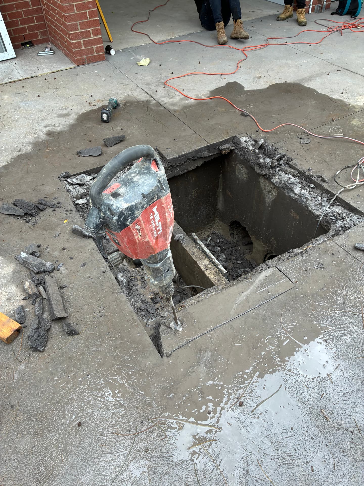 Slab cut-in and drainage pit — Concrete cut and broken out to install a new drainage pit and connection