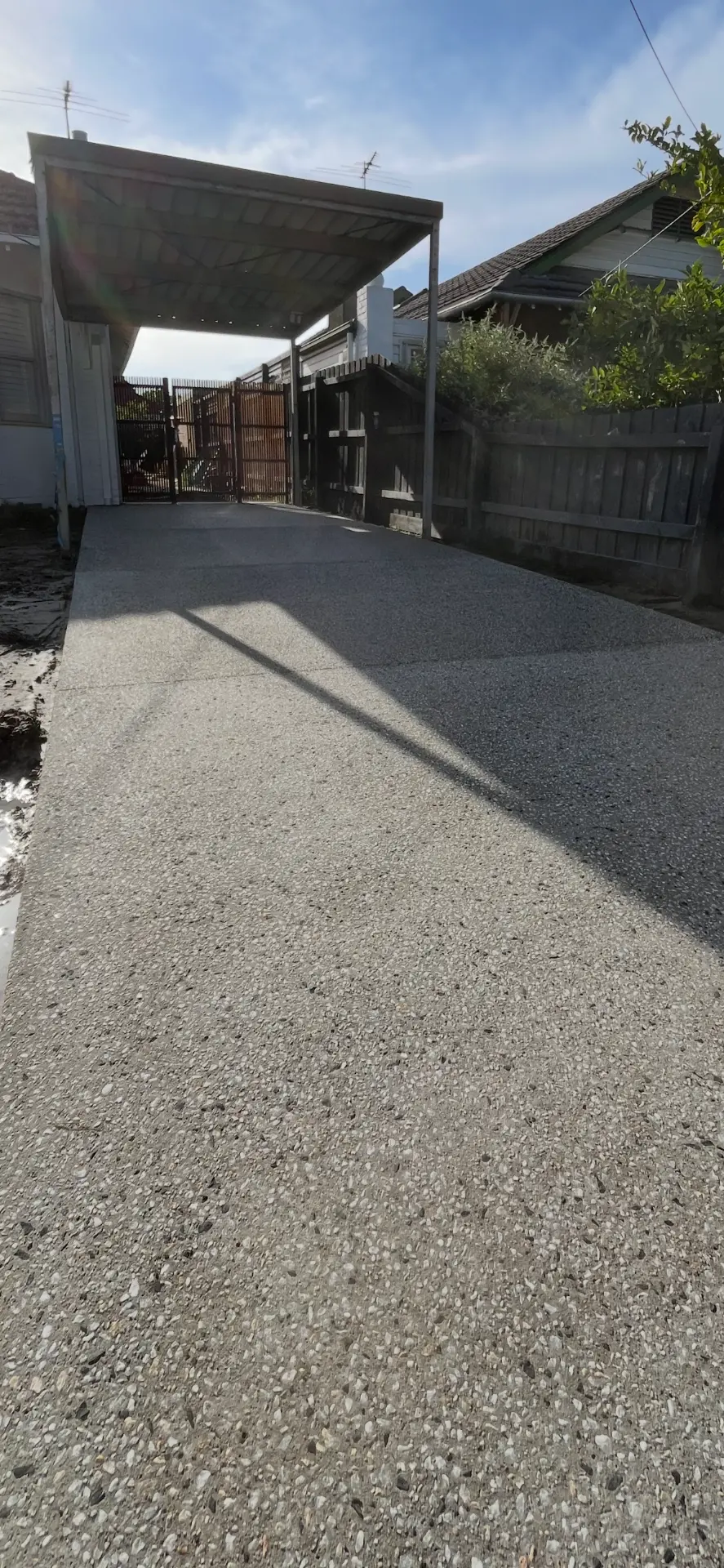 Exposed aggregate carport driveway — Full-length driveway under carport, washed aggregate finish with fall to the street