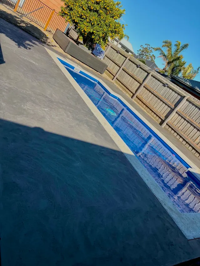 Charcoal concrete pool surround — Coloured charcoal concrete pool edge and surround poured as one continuous finish